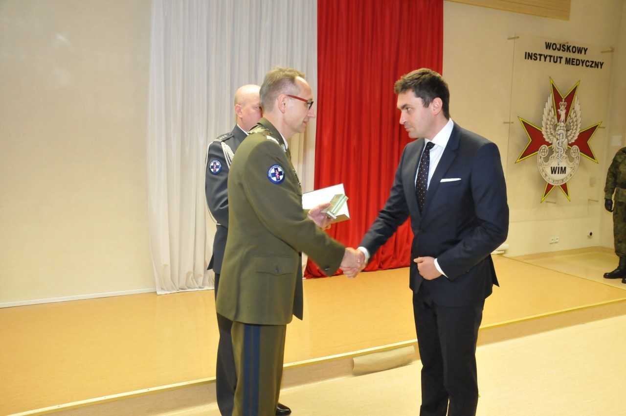 Dyrektor WIM Grzegorz Gielerak wręcza nagrodę laureatowi.