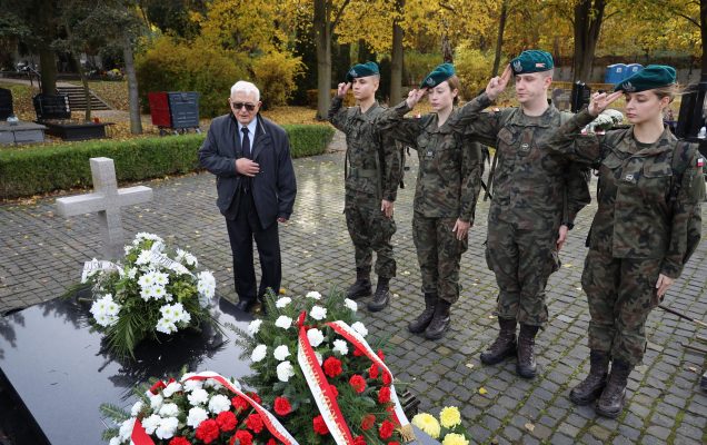 Żołnierze salutują zmarłym żołnierzom nad ich grobami.