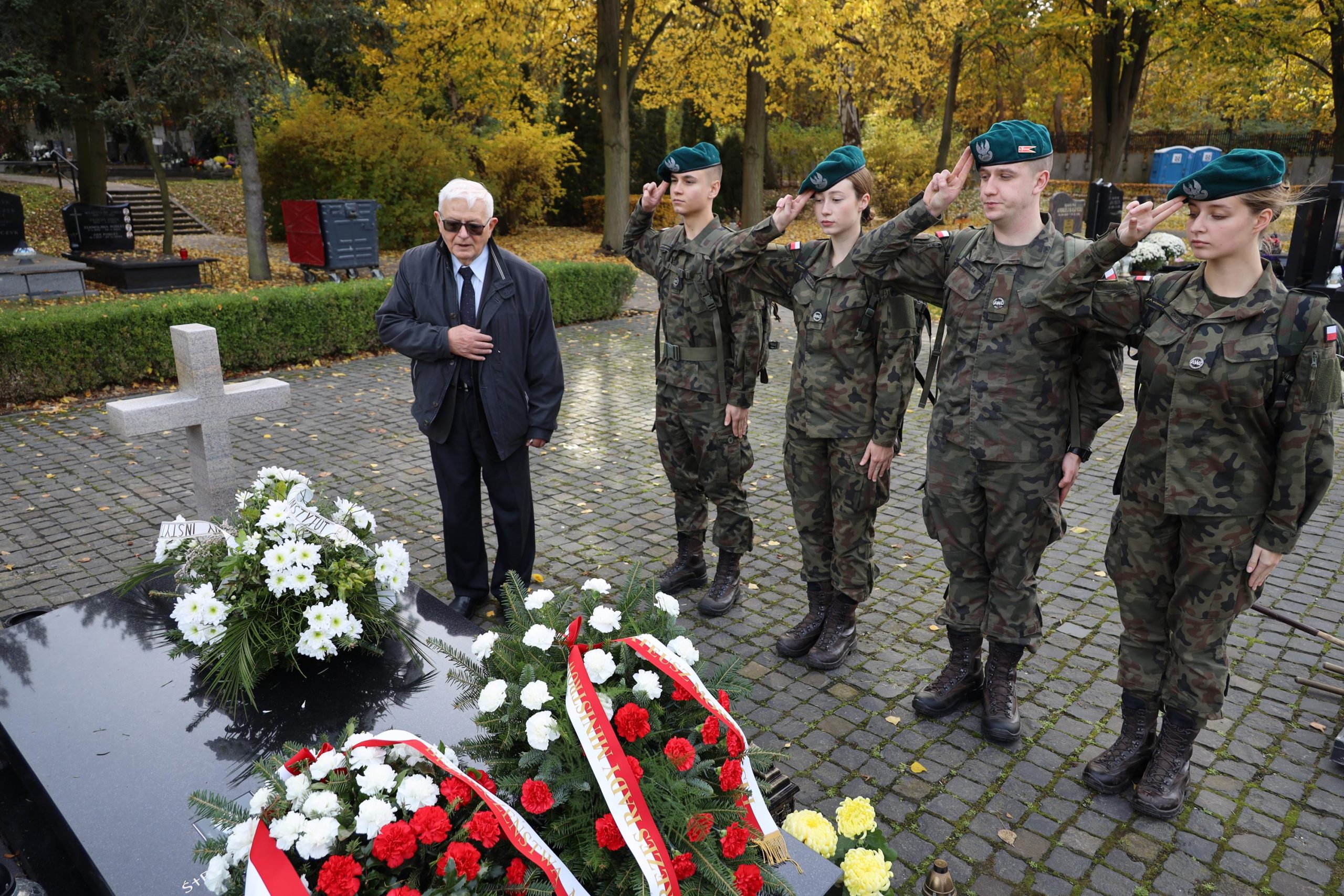 Żołnierze salutują zmarłym żołnierzom nad ich grobami.