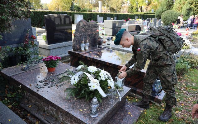 Żołnierz zapala znicz dla zmarłego żołnierza.