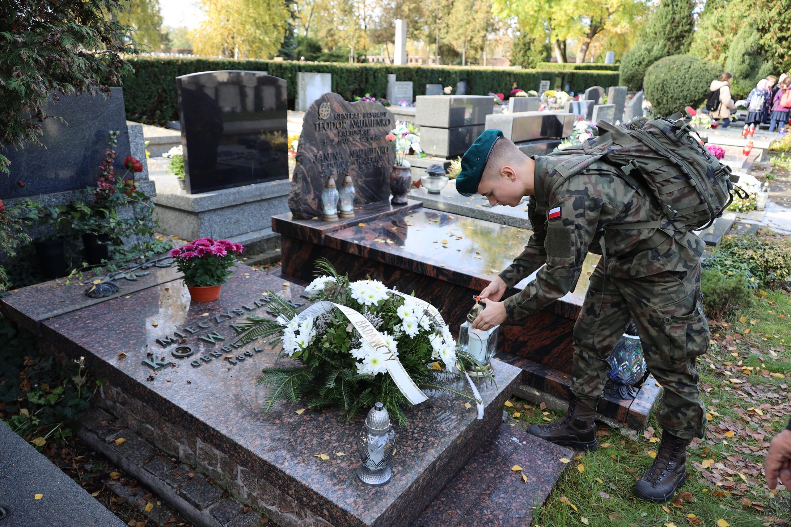 Żołnierz zapala znicz dla zmarłego żołnierza.