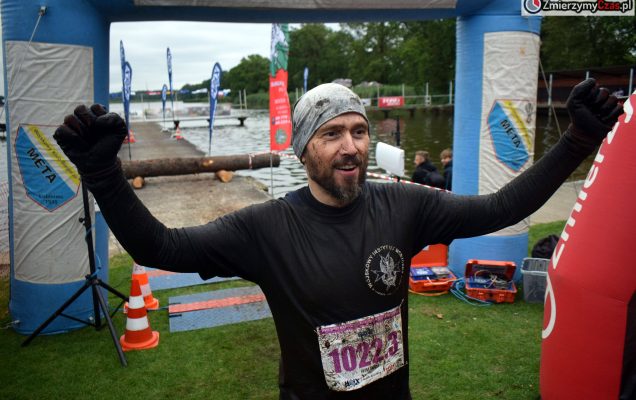 Pracownik WIM stoi triumfalnie po skończonym biegu.