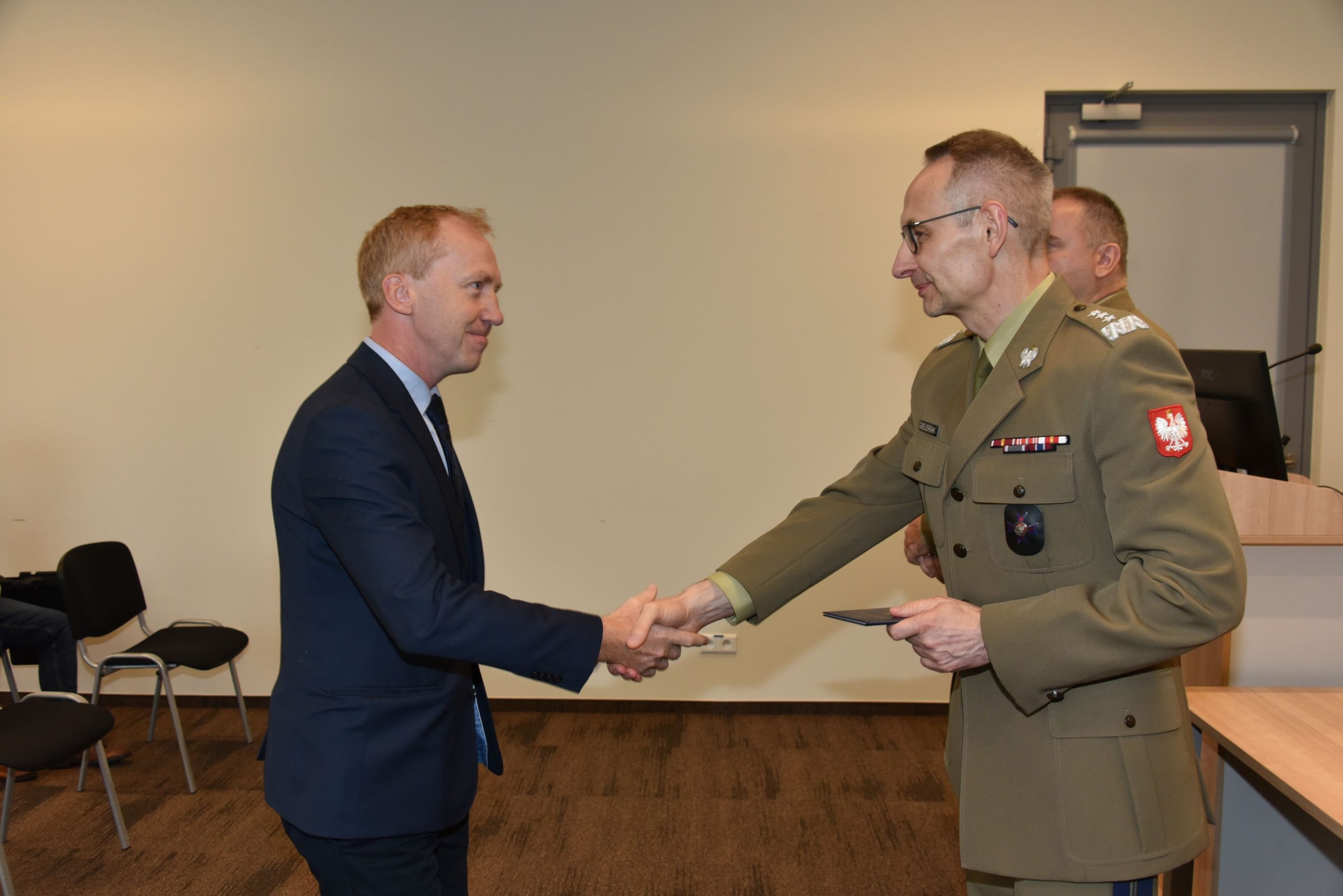 Inauguracja studiów podyplomowych mon w wojskowym instytucie medycznym. Dyrektor WIM podaję rękę studentom.