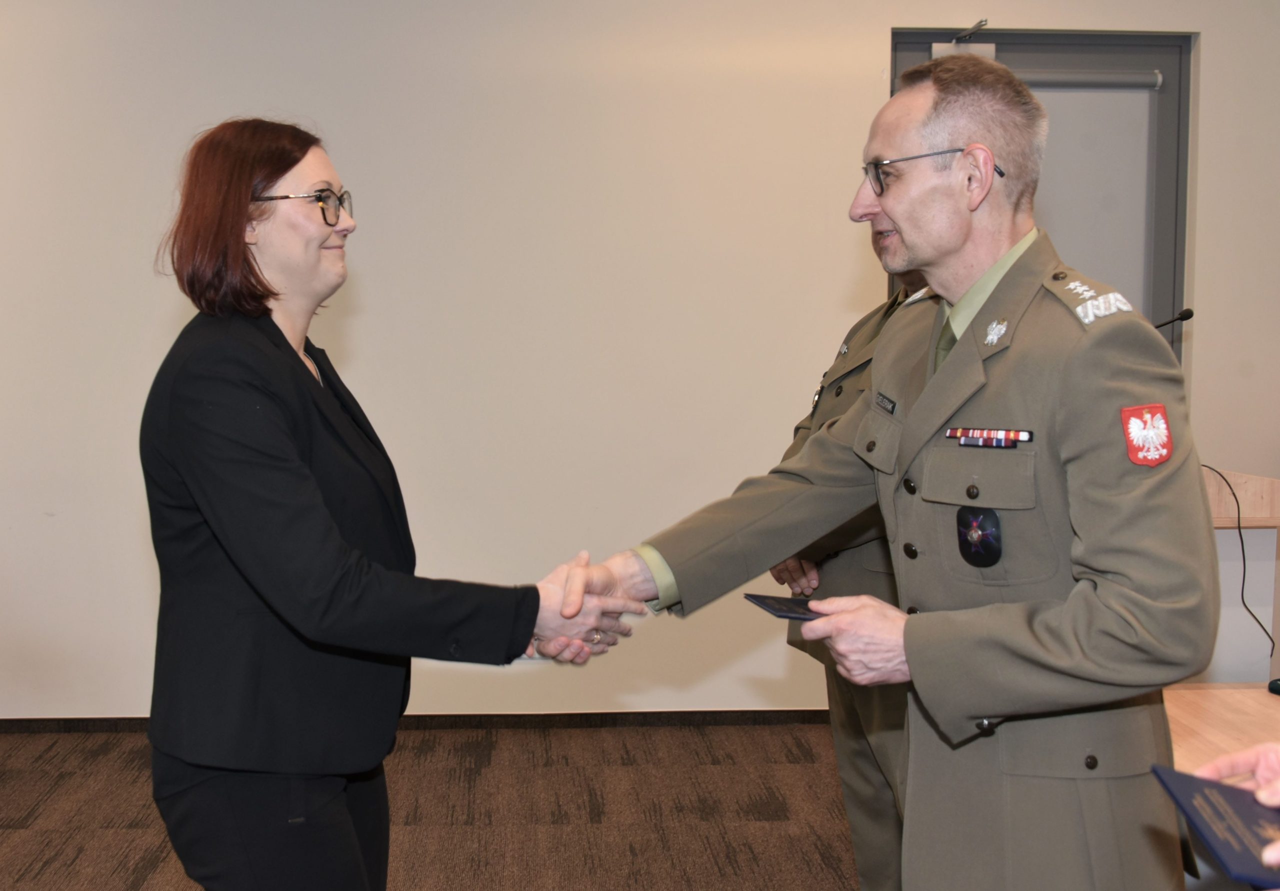 Inauguracja studiów podyplomowych mon w wojskowym instytucie medycznym. Dyrektor WIM podaję rękę studentom.