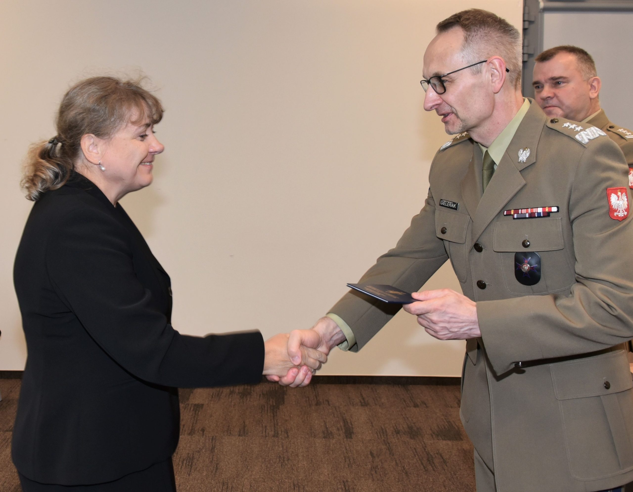Inauguracja studiów podyplomowych mon w wojskowym instytucie medycznym. Dyrektor WIM podaję rękę studentom.
