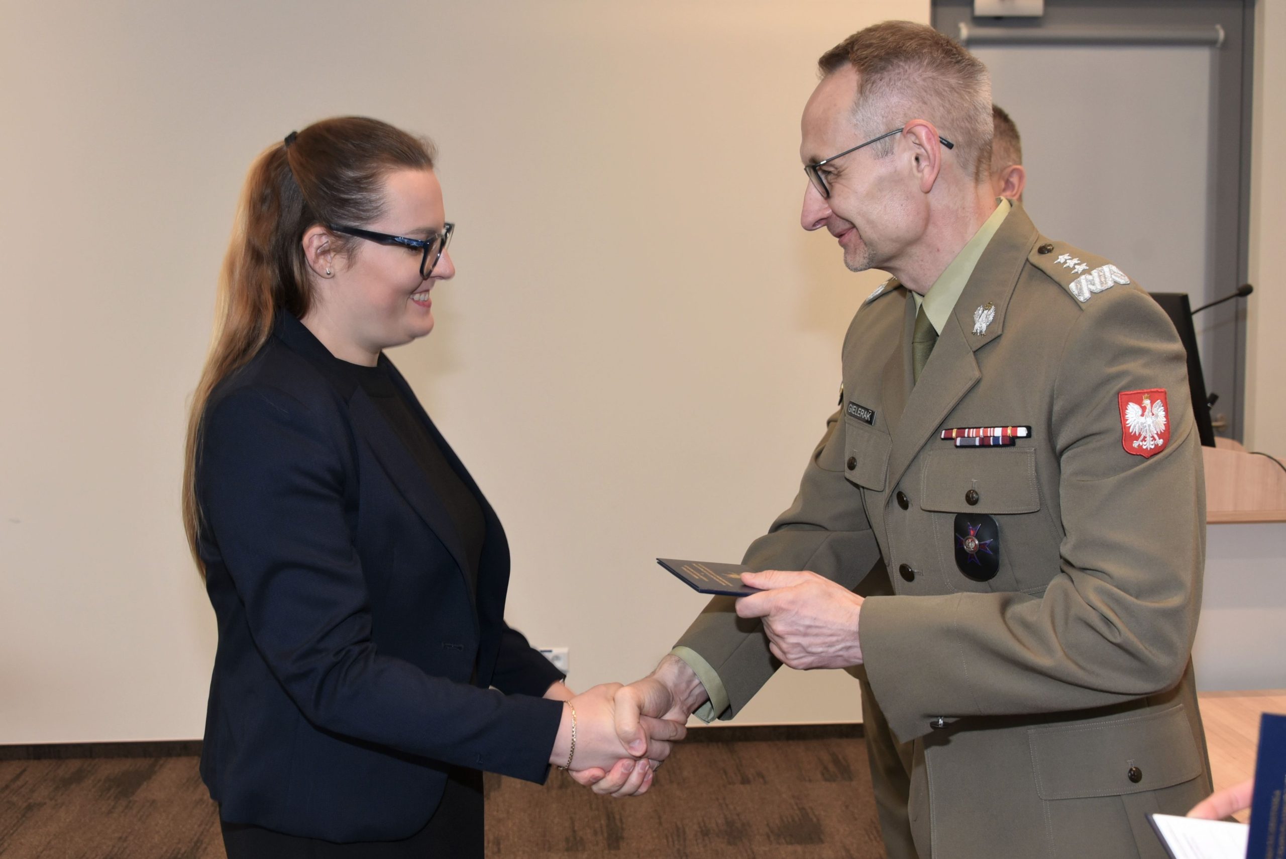 Inauguracja studiów podyplomowych mon w wojskowym instytucie medycznym. Dyrektor WIM podaję rękę studentom.