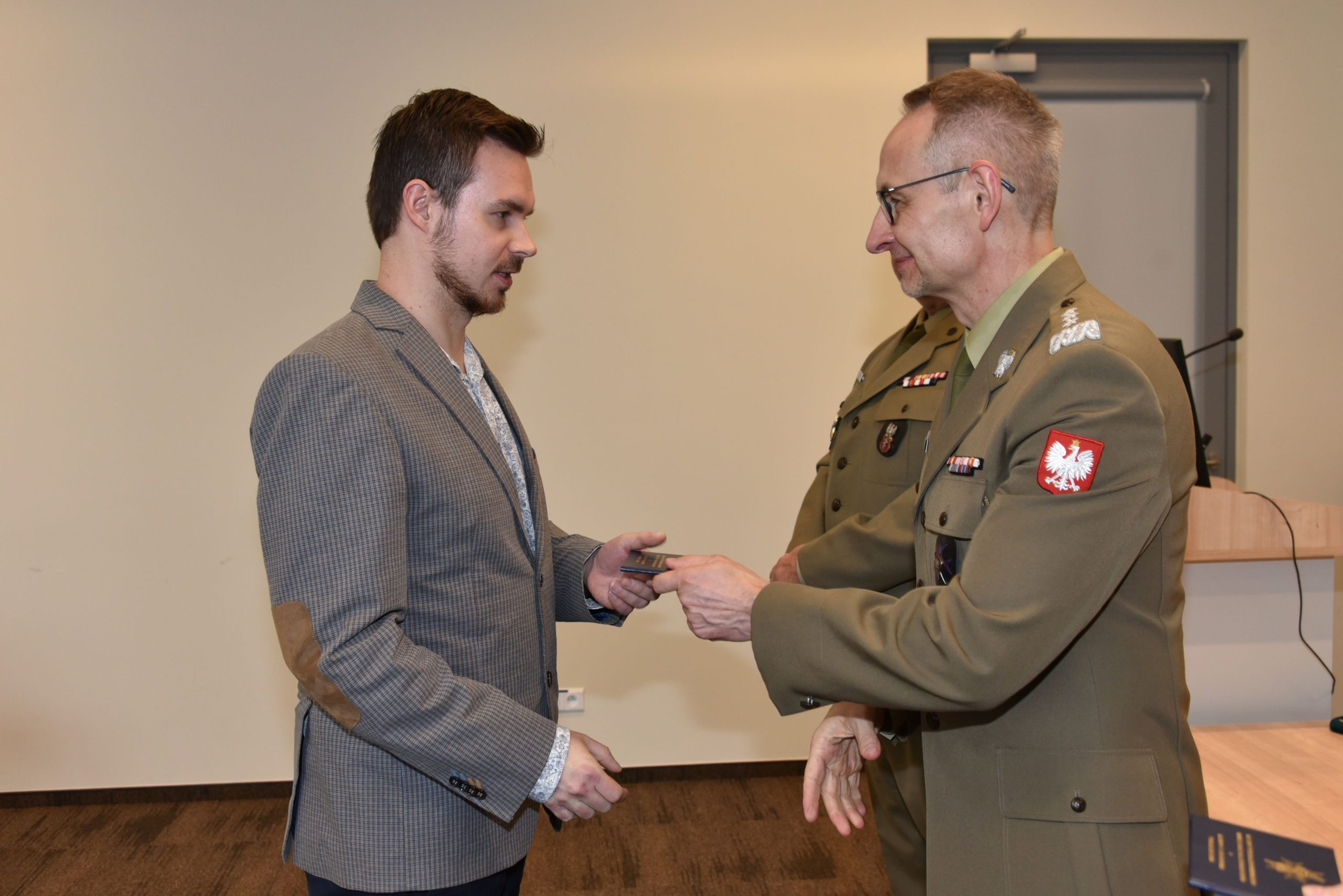 Inauguracja studiów podyplomowych mon w wojskowym instytucie medycznym. Dyrektor WIM podaję rękę studentom.