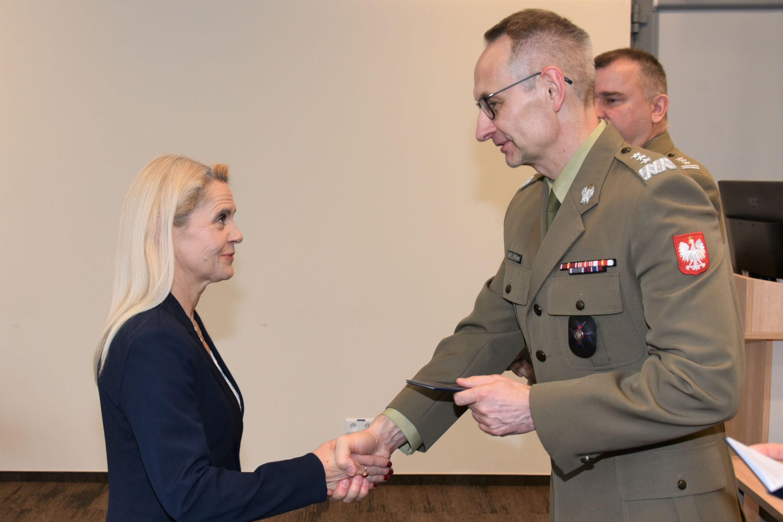 Inauguracja studiów podyplomowych mon w wojskowym instytucie medycznym. Dyrektor WIM podaję rękę studentom.