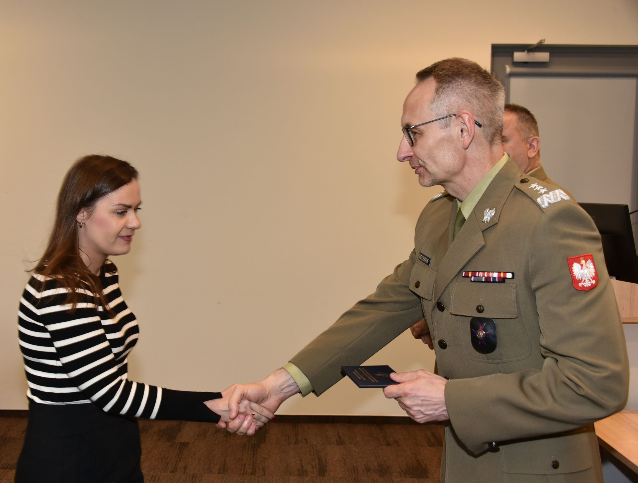 Inauguracja studiów podyplomowych mon w wojskowym instytucie medycznym. Dyrektor WIM podaję rękę studentom.
