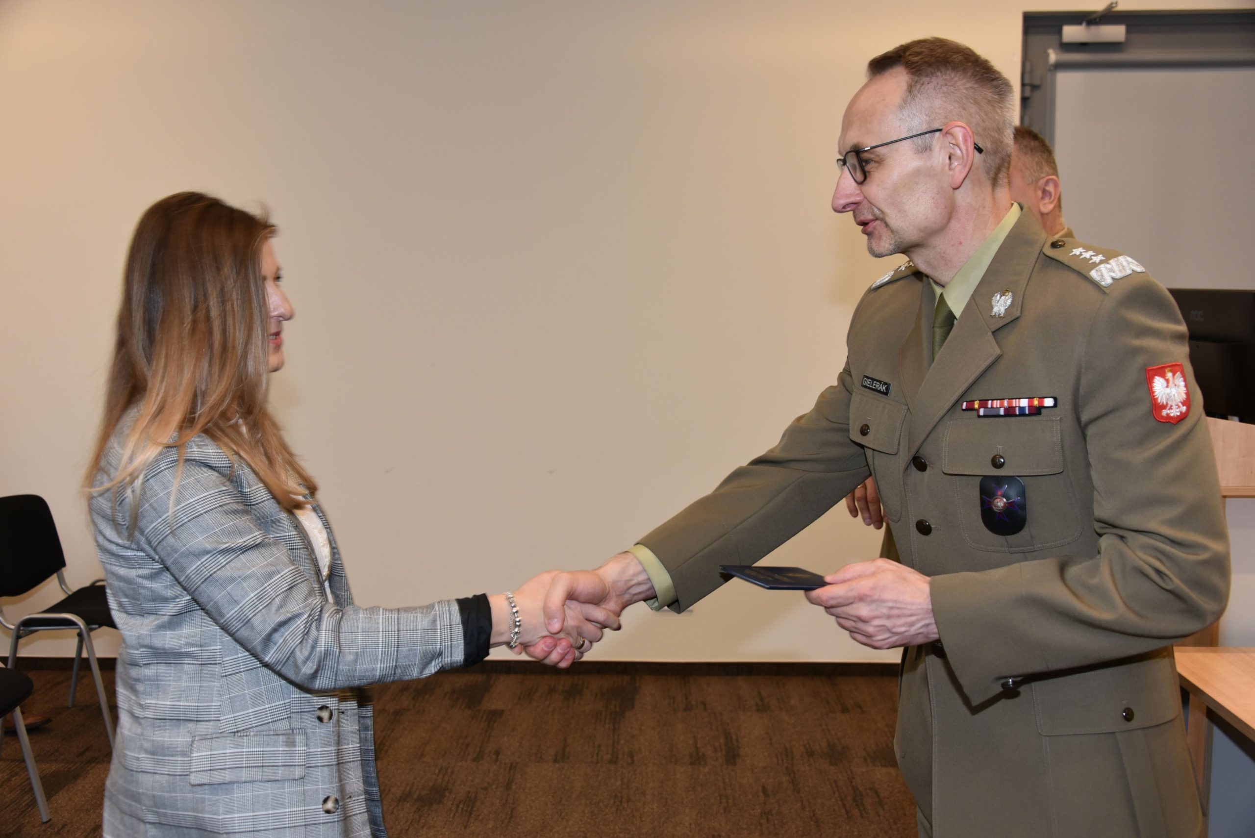 Inauguracja studiów podyplomowych mon w wojskowym instytucie medycznym. Dyrektor WIM podaję rękę studentom.