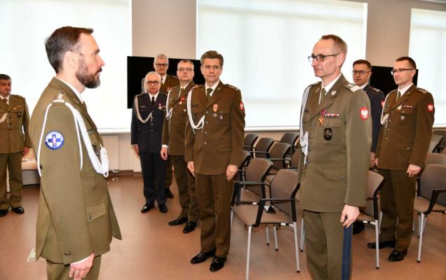 Arur Bachta i Grzegorz Gielerak stoją na przeciw siebie podczas uroczystości wręczenia odznaczeń.