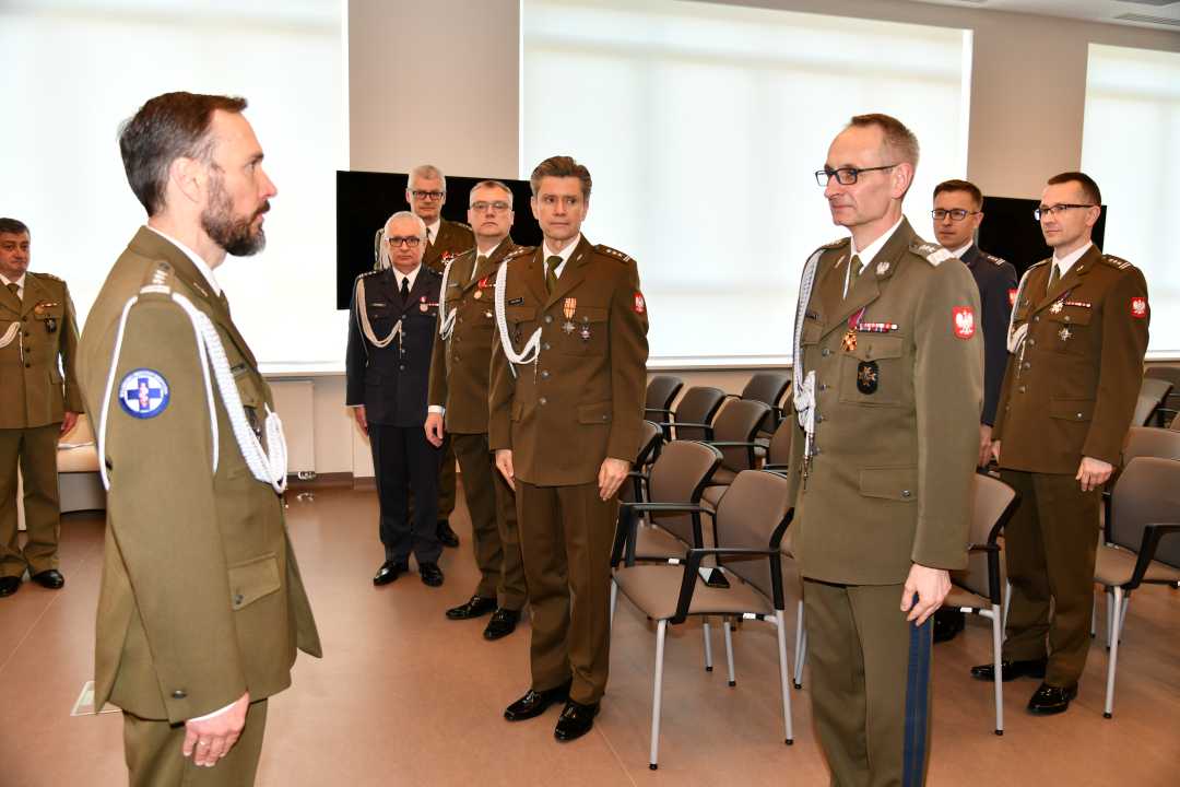 Arur Bachta i Grzegorz Gielerak stoją na przeciw siebie podczas uroczystości wręczenia odznaczeń.