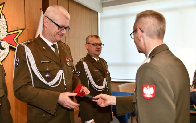 Dyrektor WIM wręcza Robertowi Ryczkowi odznaczenie.