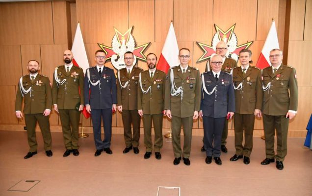 Zdjęcie grupowe. W środku dyrektor WIM Grzegorz Gielerak obok wszyscy odznaczeni pracownicy WIM.