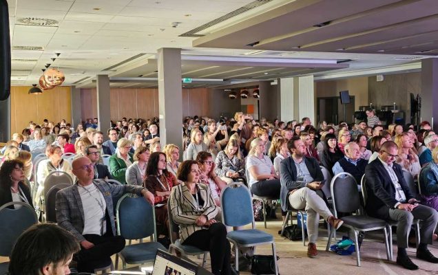 Słuchacze siedzący na sali podczas wykładu na konferencji.