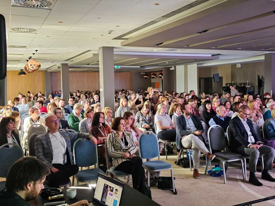 Słuchacze siedzący na sali podczas wykładu na konferencji.