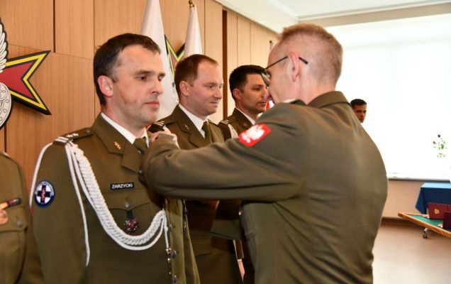 Grzegorz Gielerak wręcza odznaczenie Krzysztofowi Zarzyckiemu.