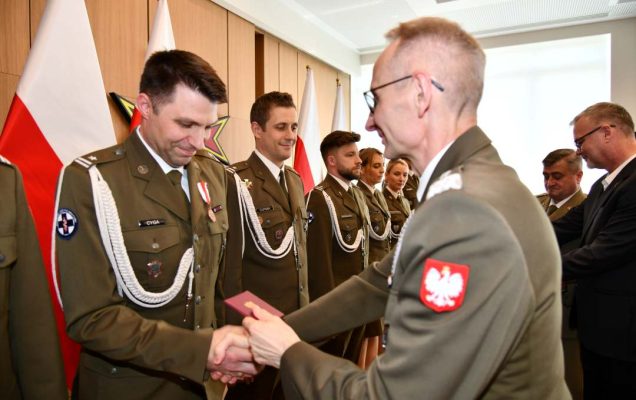 Grzegorz Gielerak wręcza odznaczenie Remigiuszowi Cyga.
