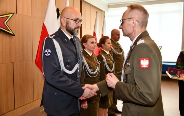 Grzegorz Gielerak wręcza odznaczenie Piotrowi Zięcinie.