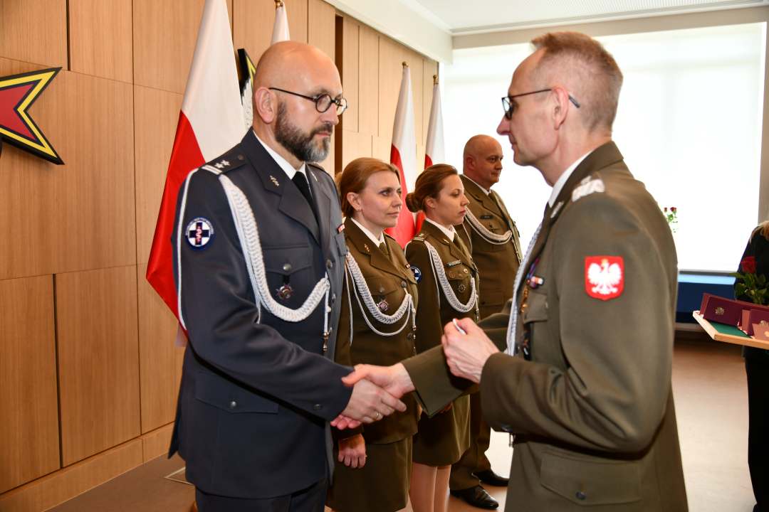 Grzegorz Gielerak wręcza odznaczenie Piotrowi Zięcinie.