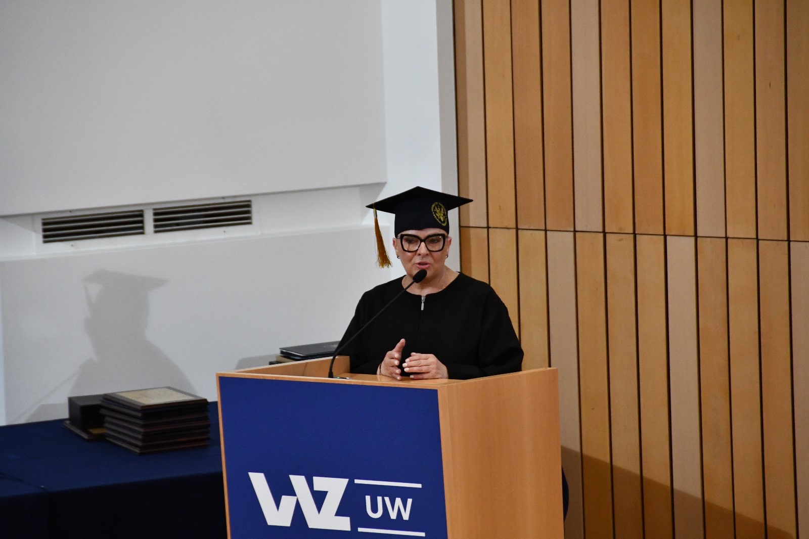 Lidia Wojda w todze przy mównicy.