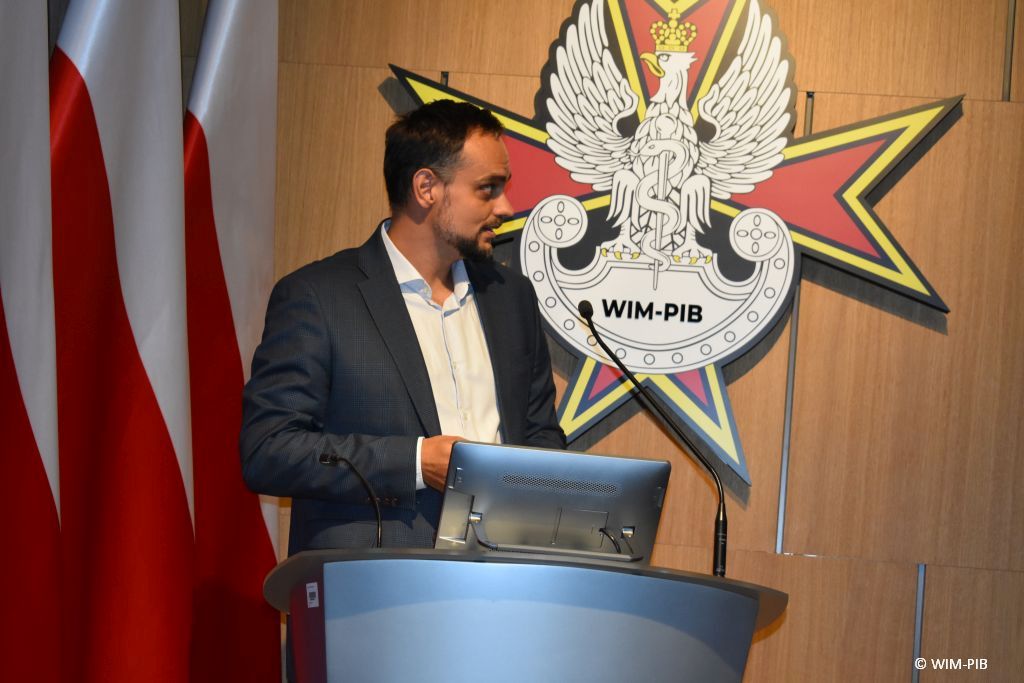 Prelegent konferencji przy mównicy.