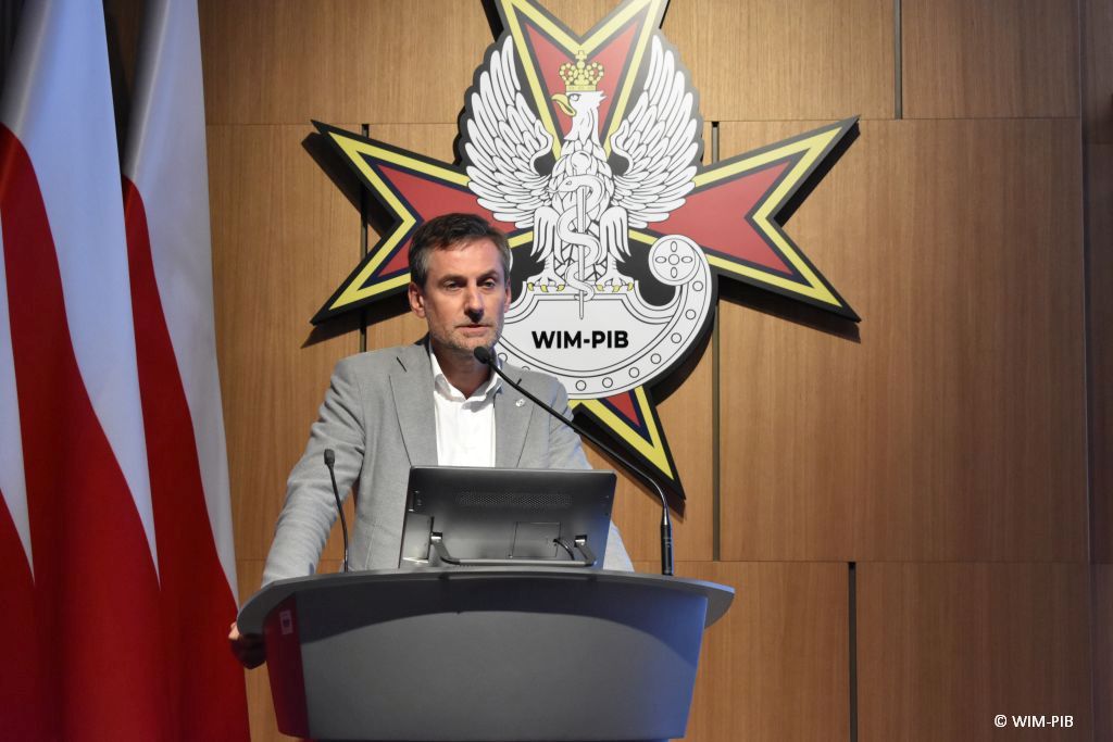 Prelegent konferencji przy mównicy.
