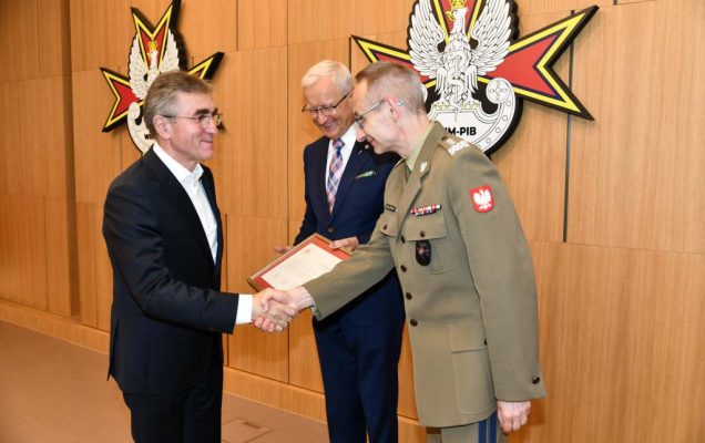 Wojciech Marczyński i Grzegorz Gielerak wręczają dyplom członkowi Rady.