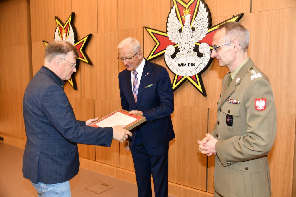Wojciech Marczyński i Grzegorz Gielerak wręczają dyplom członkowi Rady.