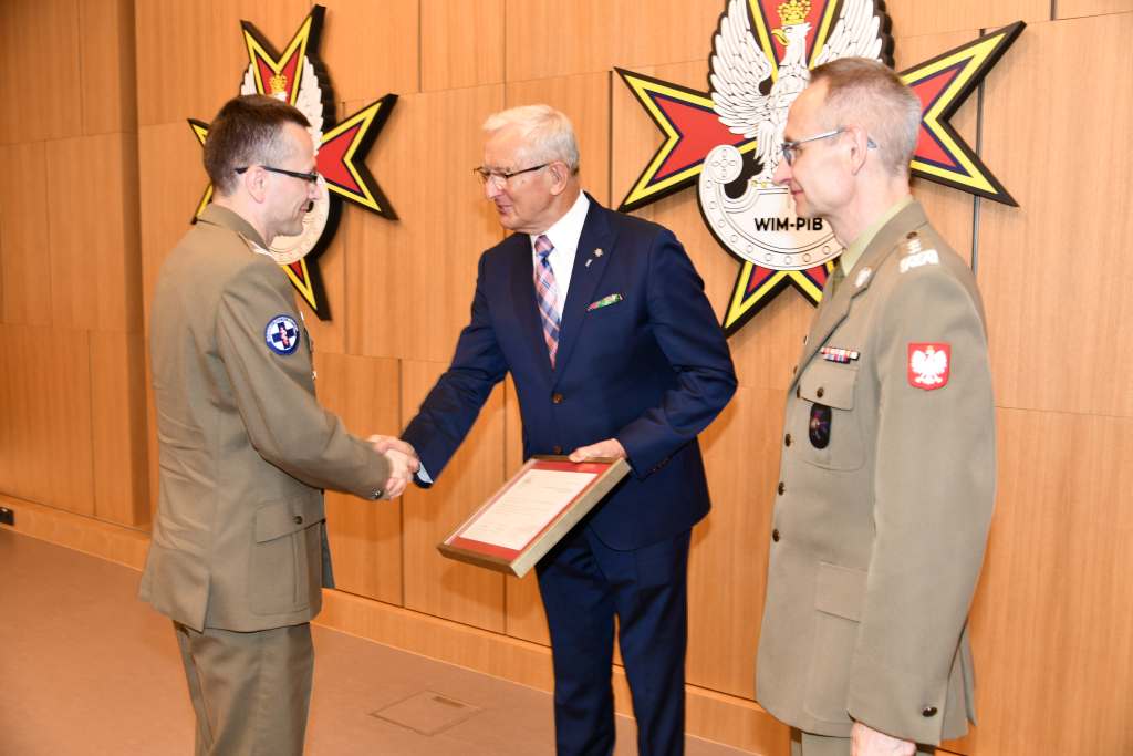 Wojciech Marczyński i Grzegorz Gielerak wręczają dyplom członkowi Rady.