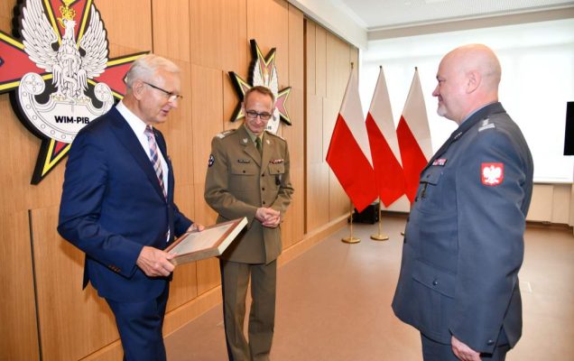Wojciech Marczyński i Grzegorz Gielerak wręczają dyplom profesorowi Markowi Rękasowi.