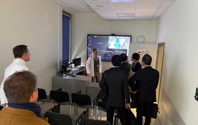 Delegacja z Japonii z lekarzami WIM na sali podczas szkolenia. W tyle sali na ścianie ekran z prezentacją.