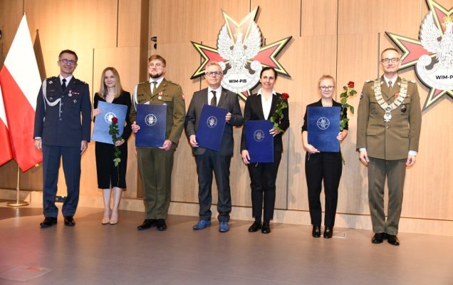 Laureaci z dyplomami pozują do zdjęcia z Dyrektorem WIM, zdjęcie grupowe. Od lewej: Paweł Krzesiński, Marta Mielniczuk, Paweł Rozbicki, Hubert Burdziak, Małgorzata Gajewska, Wanesa Wilczyńska, Grzegorz Gielerak.