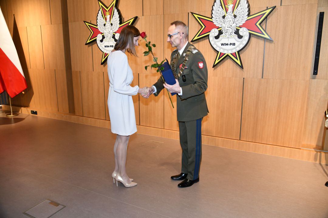 Dyrektor WIM wręcza dyplom i ściska rękę Aleksandrze Majewskiej.