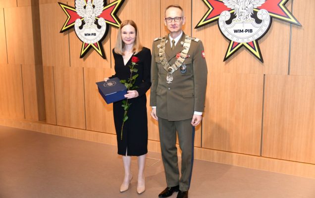 Dyrektor WIM pozuje z doktor Martą Mielniczuk trzymającą nagrodę oraz czerwoną różę