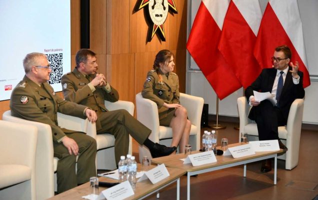 Uczestnicy siedzący w fotelach podczas panelu dyskusyjnego, za ich plecami wyświetlony fragment prezentacji.