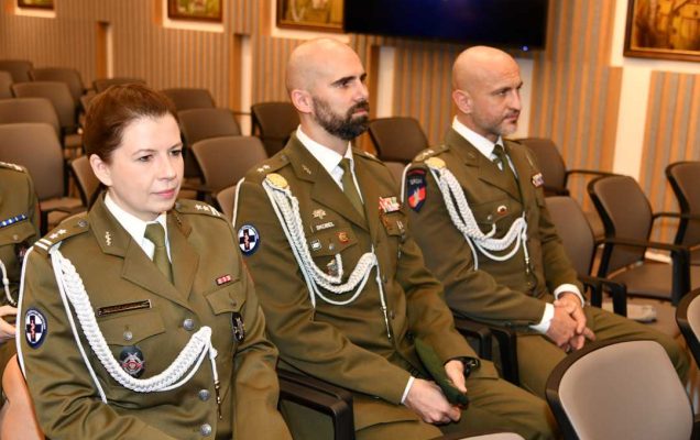 Uczestnicy siedzący na auli ubrani w wojskowe mundury.