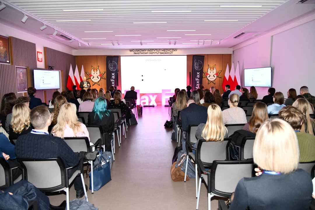 Ujecie z tyłu sali siedzących słuchaczy.