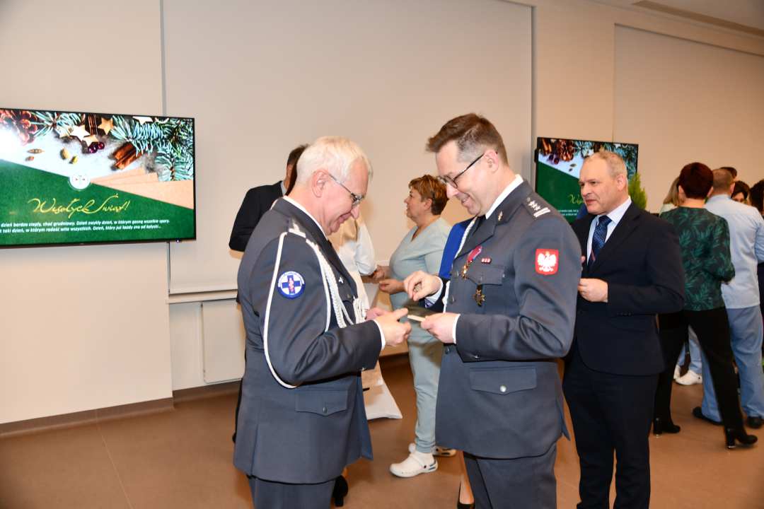 Goście i pracownicy dzielą się opłatkiem.