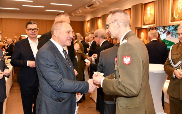 Dyrektor WIM dzieli się opłatkiem z pracownikami i gośćmi.