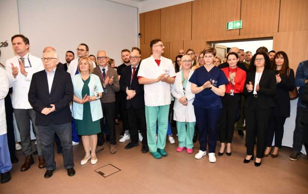 Zaproszeni pracownicy i goście stoją na auli WIM-PIB.