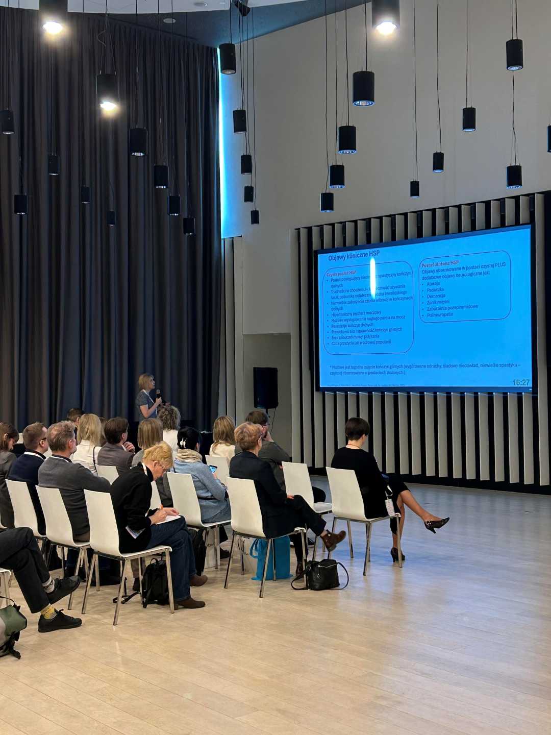 Ujęcie z tyłu sali słuchaczy podczas wykładu na sali konferencyjnej.