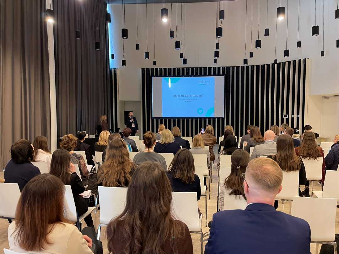 Ujęcie z tyłu sali słuchaczy podczas wykładu na sali konferencyjnej.