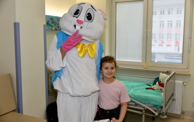 Zajączek wielkanocny z małą pacjentką w sali szpitalnej.