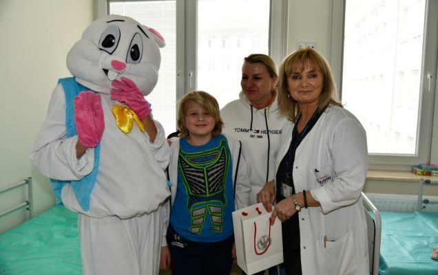 Zajączek wielkanocny w sali szpitalnej z młodym pacjentem i pracownikami kliniki pediatrycznej.