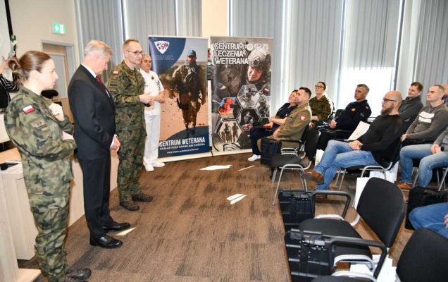 Sala wykładowa WIM. Od lewej: Agnieszka Grabińska, Stanisław Wziątek,Grzegorz Gielerak, Jarosław Świstak stoją na przeciw siedzących słuchaczy.