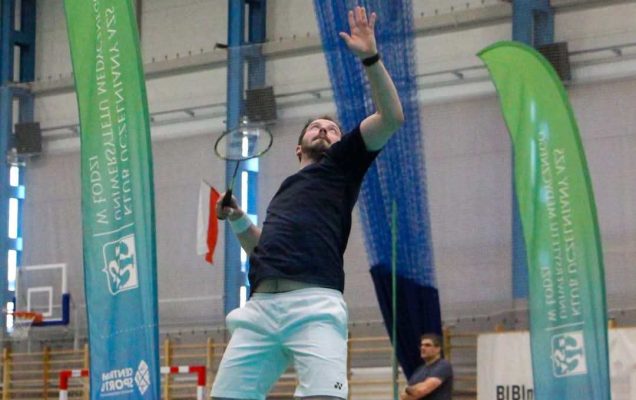 Wojciech Kurzyński uchwycony w podskoku na hali sportowej podczas gry.