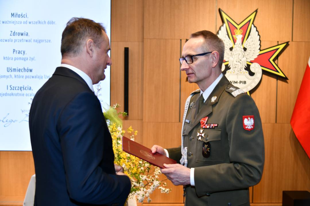 Składanie życzeń. Dyrektor WIM i pracownik WIM.
