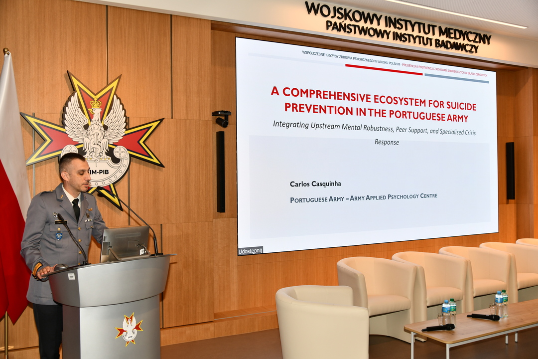 Carlos Casquinha, gość Konferencji, przy mównicy, obok niego slajd prezentacji