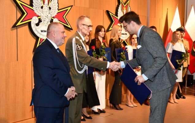 Alojzy Nowak i Grzegorz Gielerak wręczają pracownikowi WIM dyplom.